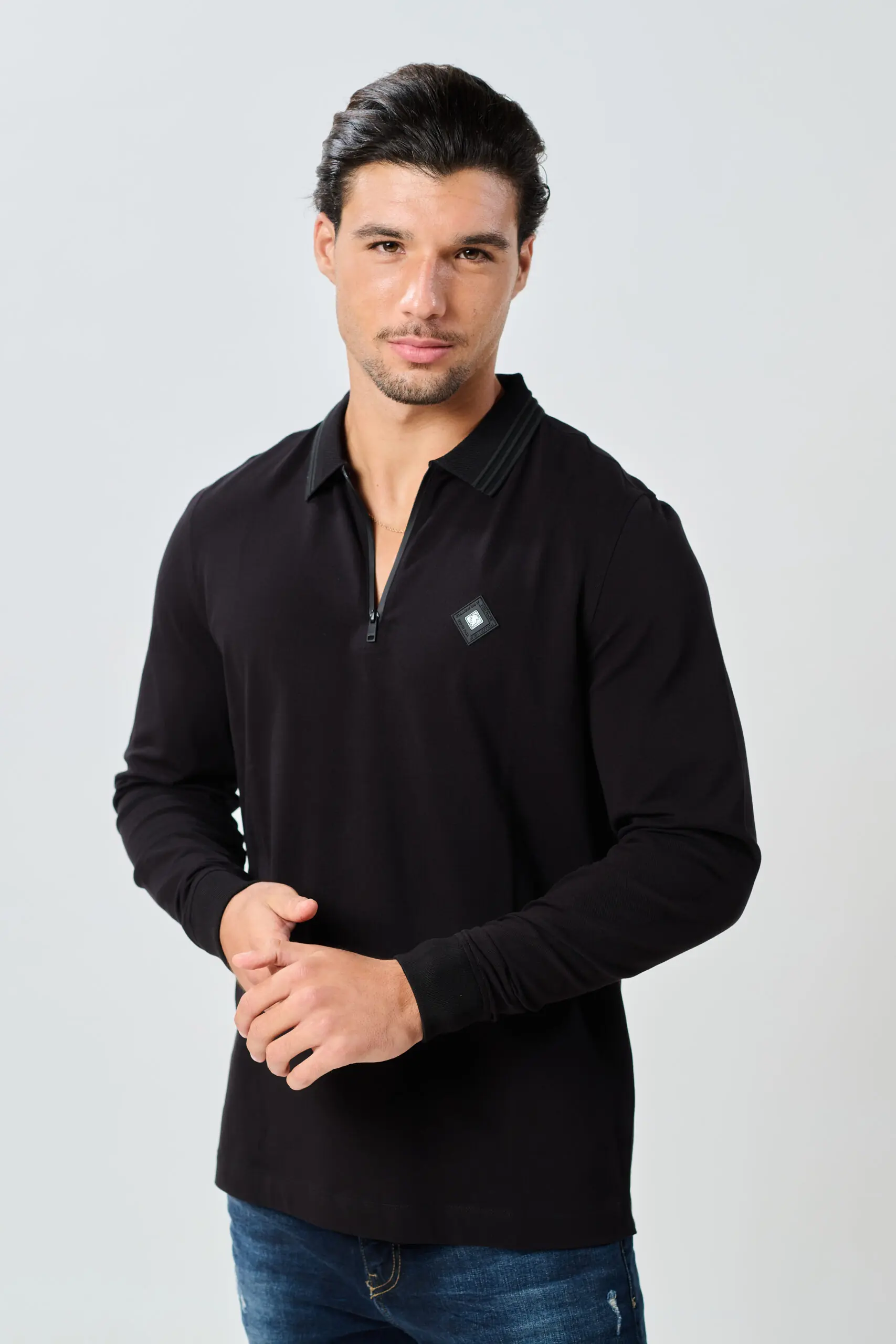 גבר לובש חולצת פולו POLO PK BB שחורה עם רוכסן קצר ועמידה אלגנטית