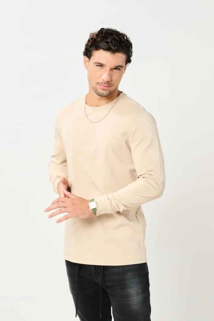 דגם T SHIRT ROMA של BOGART בגזרת טי שירט ארוכה בצבע BEIGE, על דוגמן בלבוש יומיומי אלגנטי.